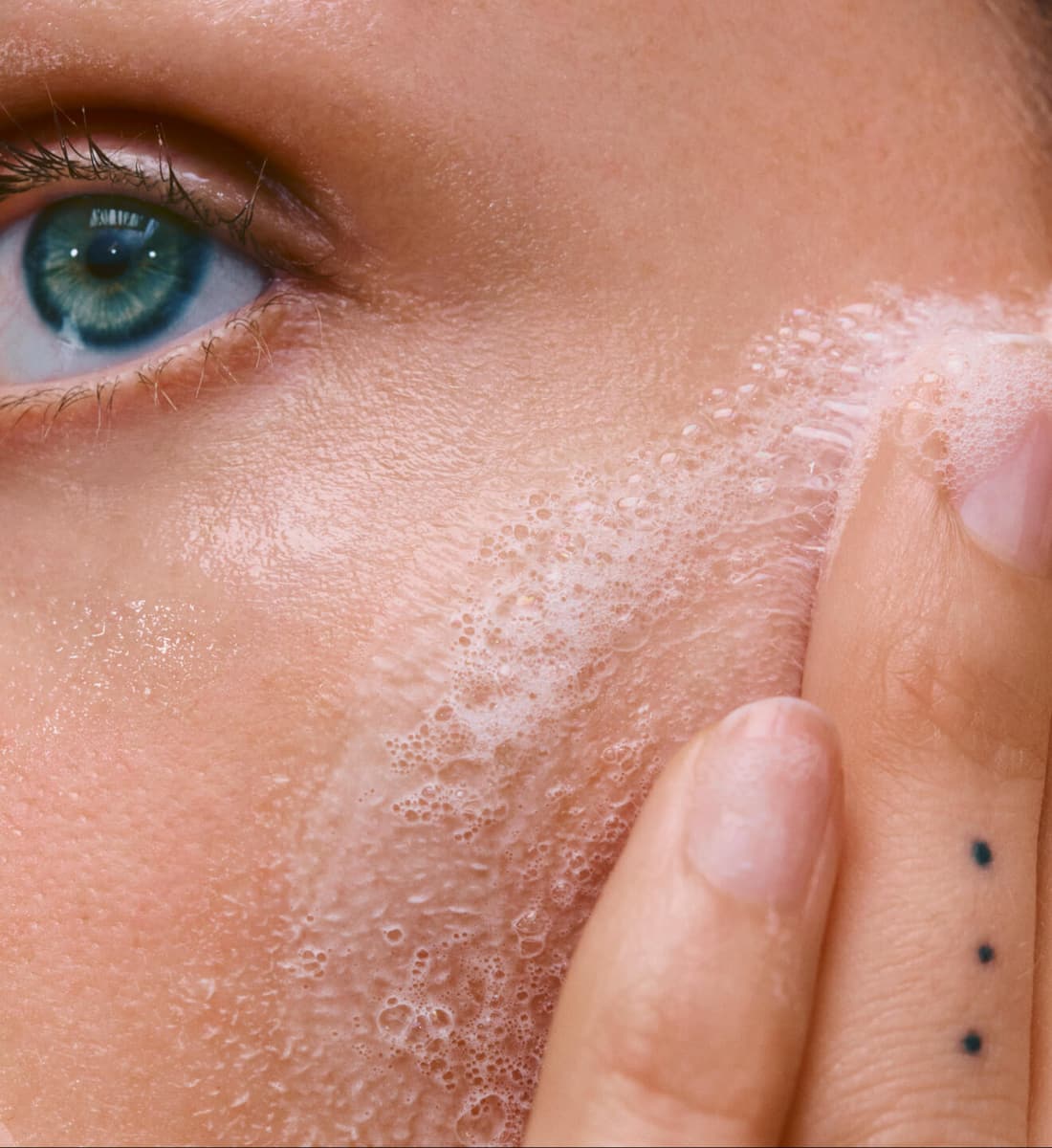 close up of a model's face with bubbles on her face
